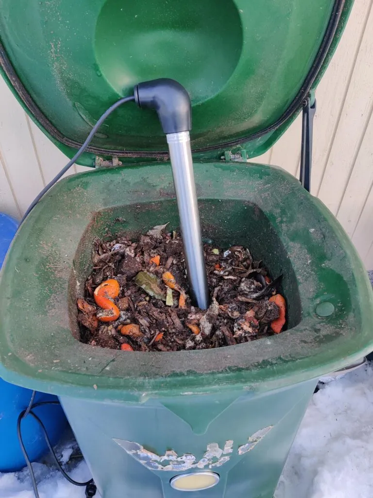 Sulana putkilämmitin kompostissa valmiina työnnettäväksi biojätteen sekaan.